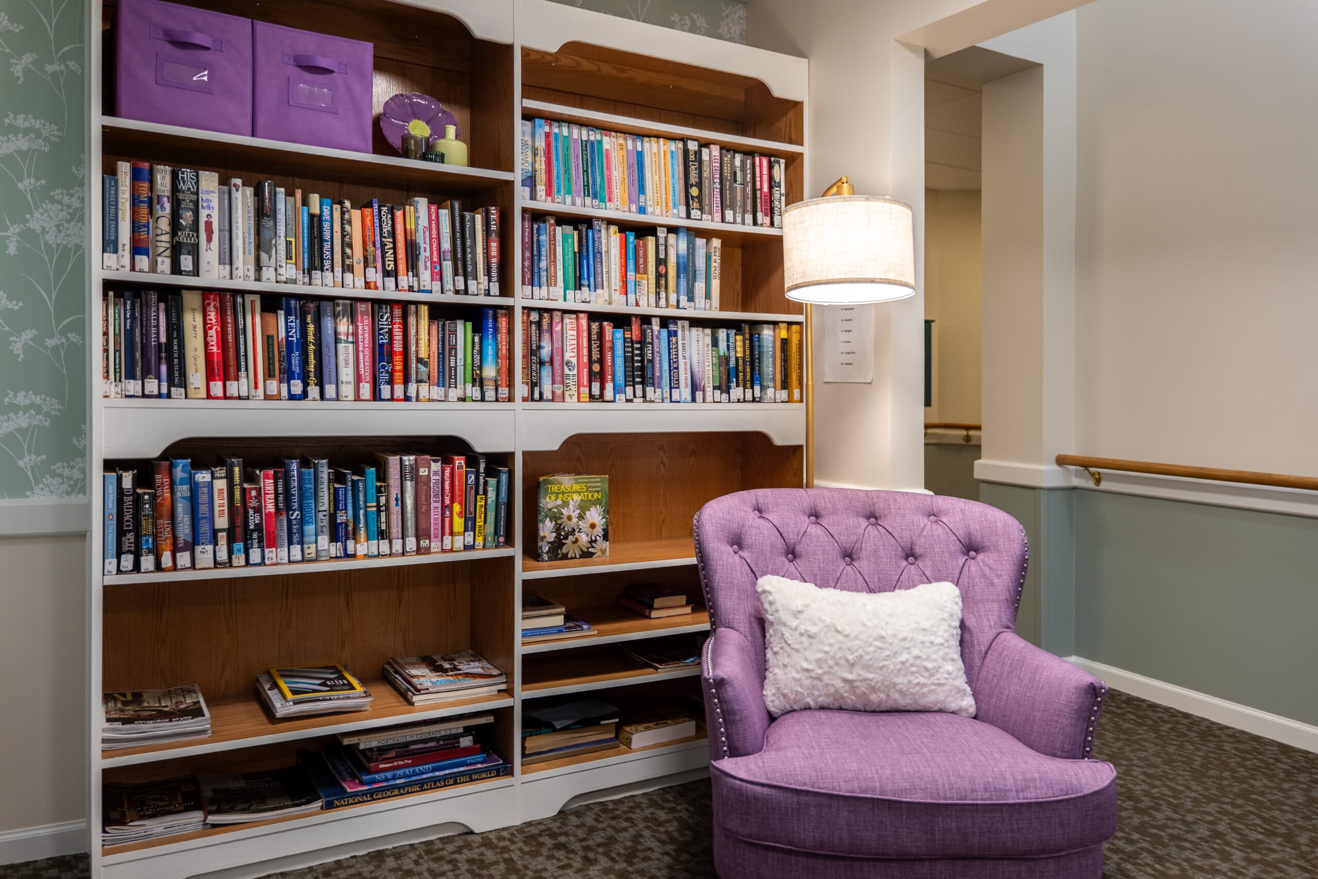 A library and seating area with a purple chair and purple accents.